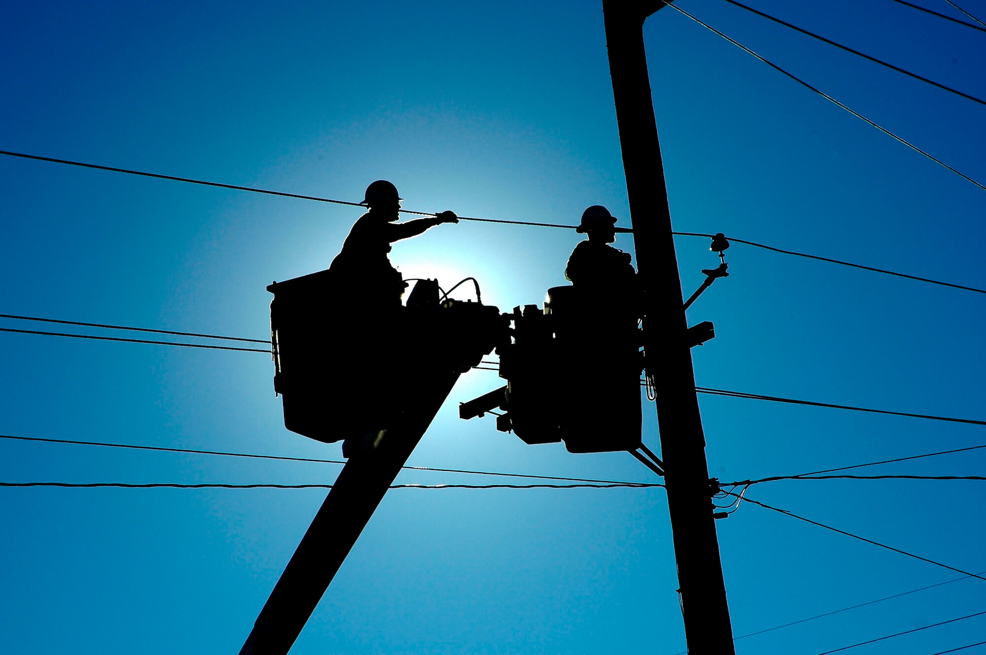 Abbildung zeigt Servicetechniker an Stromleitungen