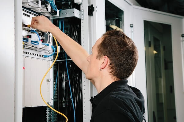 Abbildung zeigt Techniker am Datenschrank
